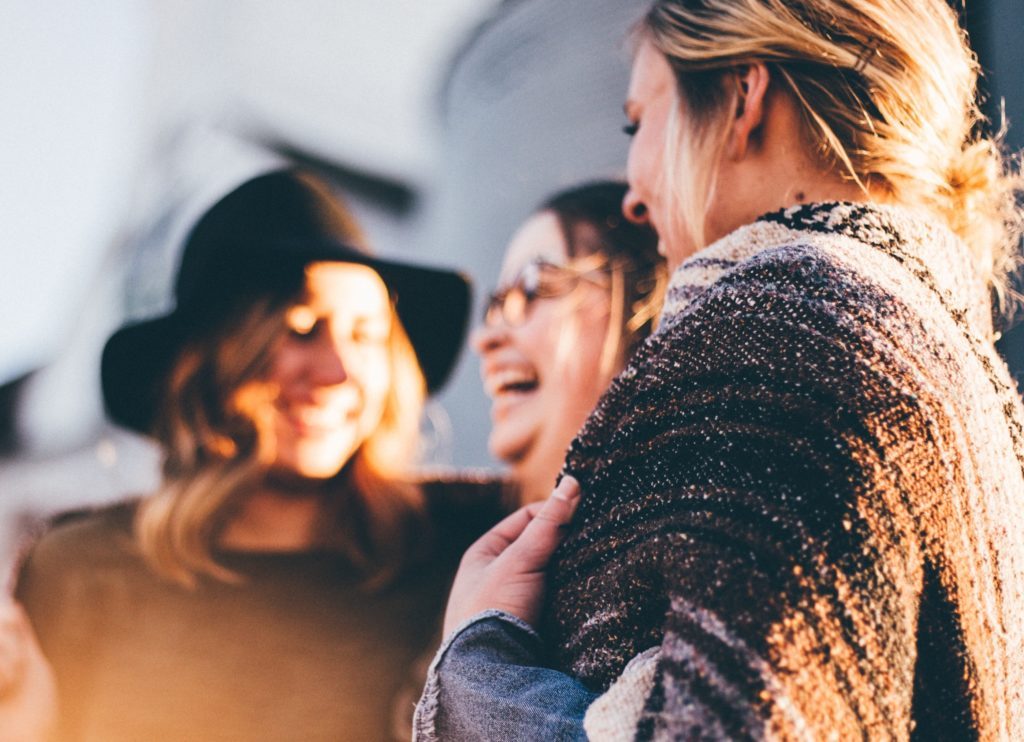 three women laughing together in a circle