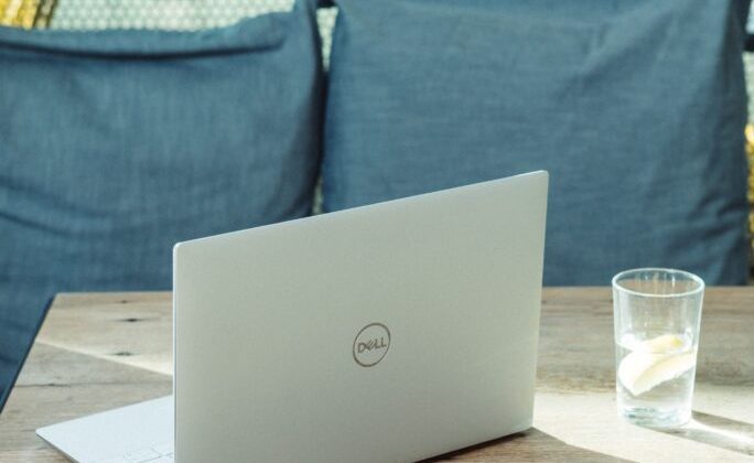 silver laptop on brown wooden table